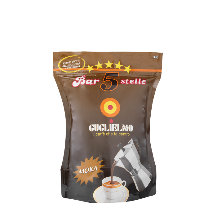 Eine braune wiederverschließbare Aromaverpackung für den gemahlenen Mokka Kaffee Guglielmo Bar 5 Stelle. In der Mitte sieht man das Logo von Guglielmo mit dem orange,gelb, roten konzentrischen Kreis. Darunter ist eine Aluminium Mokkakanne abgebildet welche frisch gebrühten Kaffee in eine weiße Tasse eingießt. Darüber befindet sich der weiße Schiftzug mit rotem Rand Bar 5 Stelle mit 5 gelben Sternen darüber.