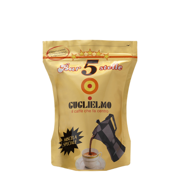 Eine goldene wiederverschließbare Aromaverpackung für den gemahlenen Mokka Kaffee Guglielmo Bar 5 Stelle Oro. In der Mitte sieht man das Logo von Guglielmo mit dem orange,gelb, roten konzentrischen Kreis. Darunter ist eine Aluminium Mokkakanne abgebildet welche frisch gebrühten Kaffee in eine weiße Tasse eingießt. Darüber befindet sich der weiße Schiftzug mit rotem Rand Bar 5 Stelle mit 5 gelben Sternen darüber.
