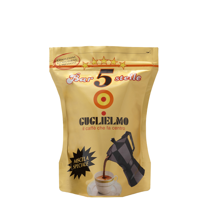 Eine goldene wiederverschließbare Aromaverpackung für den gemahlenen Mokka Kaffee Guglielmo Bar 5 Stelle Oro. In der Mitte sieht man das Logo von Guglielmo mit dem orange,gelb, roten konzentrischen Kreis. Darunter ist eine Aluminium Mokkakanne abgebildet welche frisch gebrühten Kaffee in eine weiße Tasse eingießt. Darüber befindet sich der weiße Schiftzug mit rotem Rand Bar 5 Stelle mit 5 gelben Sternen darüber.