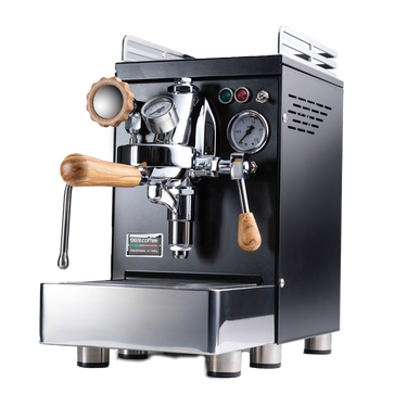 Die Espressomaschine Elba Quattro V02  in schwarz mit Drehrad aus Olivenholz. Auf der linken Seite befindet sich der Dampfhahn, in der Mitte die Faema E-61 Brühgruppe. Darunter die abnehmbare Abtropftasse. Darüber eine Reling um das Herunterfallen der Tassen zu vermeiden.