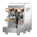 Die Espressomaschine Elba Gentile in Edelstahl mit Drehrädern aus Olivenholz. Auf der linken Seite befindet sich der Dampfhahn, auf der rechten der Teewasserhahn. Darunter die abnehmbare Abtropftasse. Darüber eine Reling um das Herunterfallen der Tassen zu vermeiden.