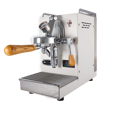 Die Espressomaschine Elba Mini in weiß mit Olivenholzgriff. In der Mitte befindet sich die Faema E-61 Brühgruppe. Darunter die herausziehbare Abtropftasse. Darüber eine Reling um das Herunterfallen der Tassen zu vermeiden, dahinter der abnehmbare Edelstahl Wassertank.