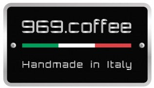 Zu sehen ist oben im Bild in weißer Schrift „969.coffee“, mittig dünn und langgezogen die italienische Fahne grün, weiß, rot, links und rechts davon 2 kleine Nieten. Darunter der Schriftzug Handmade in Italy. Der Hintergrund ist komplett in Schwarz gehalten.