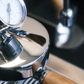Eine Detailaufnahme der Elba Gentile. Zu sehen ist die Faema E-61 Brühgruppe mit Olivenholz Siebträger. Das zentrale Detail ist das auf der Brühgruppe angebrachte Brühdruck Manometer.