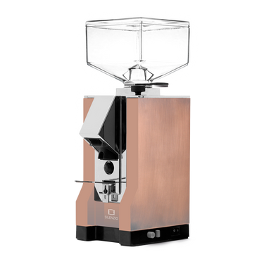 Die On-Demand Kaffeemühle Eureka Mignon Silenzio in gealtertem Kupfer mit verchromtem Auslauf. Am schwarzem Sockel befinden sich rechts unten der umschaltbare Druckknopf für Timer oder manuellen Betrieb, sowie das Drehrad für die Einstellung der Mahldauer bei Timerbetrieb. 
