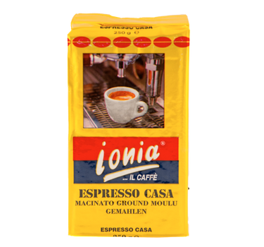 Eine goldene Vakuumverpackung für den gemahlenen Espresso Kaffee Ionia Espresso Casa. In der Mitte ist eine weiße Espressotasse mit frisch gebrühtem Kaffee mit Crema abgebildet. Diese steht auf der auf dem Abtropfgitter einer Siebträgermaschine. Darunter kann man den weißen Schriftzug Ionia Il Caffè auf einem rot/blauem Hintergrund lesen.