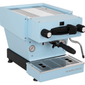 Die Schrägansicht von vorne der Espressomaschine La Marzocco Linea Mini R in hellblau. An der Oberseite ist das Paddle für den Kaffeebezug angebracht, links davon das Drehrad für Teewasser, rechts davon das Drehrad für die Dampflanze. Darunter befindet sich die Brühgruppe mit dem eingespannten Siebträger mit schwarzem Griff, darunter die Abtropftasse.