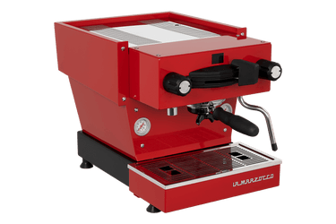 Die Schrägansicht von vorne der Espressomaschine La Marzocco Linea Mini R in rot. An der Oberseite ist das Paddle für den Kaffeebezug angebracht, links davon das Drehrad für Teewasser, rechts davon das Drehrad für die Dampflanze. Darunter befindet sich die Brühgruppe mit dem eingespannten Siebträger mit schwarzem Griff, darunter die Abtropftasse.