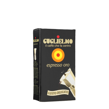 Eine schwarze Vakuumverpackung für den gemahlenen Mokka Kaffee Guglielmo Oro. Oben sieht man den goldenen Schriftzug Guglielmo il caffè che fa centro, darunter das Logo mit dem orange, gelb, roten konzentrischen Kreis. In der Mitte steht espresso oro.
Darunter ist eine schräge Aluminium Mokkakanne abgebildet. Unten die Aufschrift Gusto Delicato.