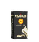 Eine schwarze Vakuumverpackung für den gemahlenen Mokka Kaffee Guglielmo Oro. Oben sieht man den goldenen Schriftzug Guglielmo il caffè che fa centro, darunter das Logo mit dem orange, gelb, roten konzentrischen Kreis. In der Mitte steht espresso oro.
Darunter ist eine schräge Aluminium Mokkakanne abgebildet. Unten die Aufschrift Gusto Delicato.