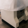 Eine Kaffeemühle Eureka Mignon Silenzio in weiß beim Auspacken. Zu sehen ist die halb ausgepackte Mühle welche zum Teil in noch in weißes Verpackungsmaterial gehüllt ist. 