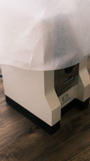 Eine Kaffeemühle Eureka Mignon Silenzio in weiß beim Auspacken. Zu sehen ist die halb ausgepackte Mühle welche zum Teil in noch in weißes Verpackungsmaterial gehüllt ist. 