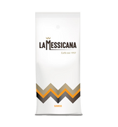 Eine weiße Kaffeepackung für Bohnen mit Aromaventil. Im oberen Teil befindet sich der schwarze Schriftzug La Messicana. Über dem M ist eine goldene Zick-zack Linie aufgedruckt, unter dem Logo in goldener Schrift Caffè dal 1957. Im unteren Teil sieht man eine über die ganze Breite verlaufende gold/orange/schwarze Zick-zack Linie. Darunter steht der orange Schriftzug Sunrise.