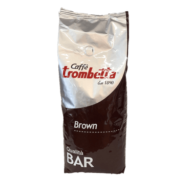 Eine silber/dunkelbraune Kaffeepackung für Bohnen mit Aromaventil. Etwas über der Mitte im silbernen Teil befindet sich der rote Schriftzug Trombetta Caffè dal 1890. Im braunen Teil der Packung ist der weiße Schriftzug Brown und Qualità BAR aufgedruckt.