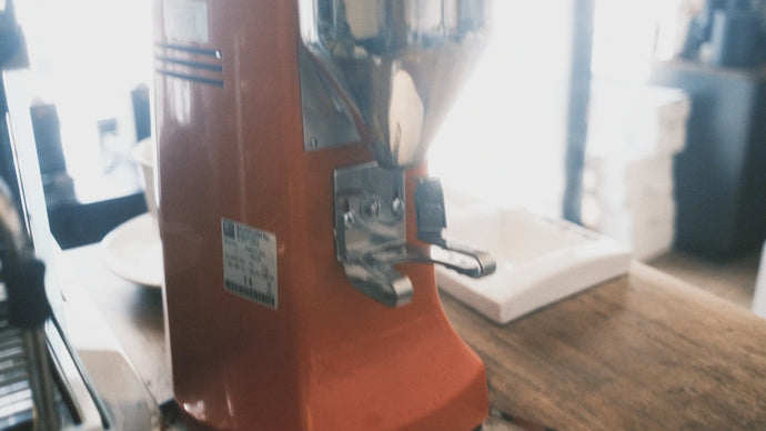 Dieses Video zeigt die Kaffeemühle Mazzer Robur S in Rot beim Mahlen von Kaffee in einen Siebträger von La San Marco. Es wird dabei abwechselnd der Auswurf des Kaffeemehls und das Display mit dem Bedienfeld fokussiert.